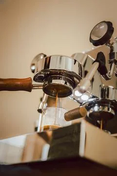 Espresso machine making an espresso with a bottomless portafilter. Stock Photos