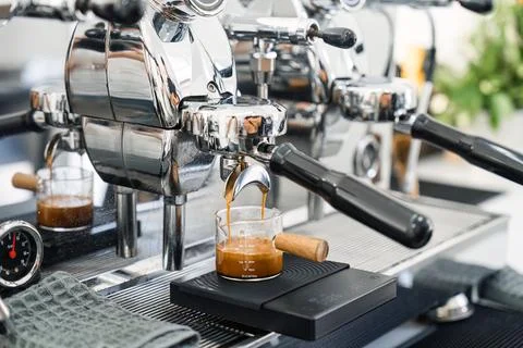 Espresso machine making hot coffee into dosing cup in coffee shop Stock Photos