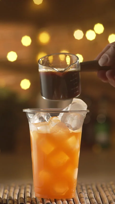 Espresso pouring into orange juice for bumble coffee Stock Footage 337898537