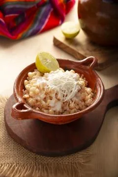 Esquites. Corn kernels cooked and served with mayo, sour cream, lemon and chi 스톡 사진