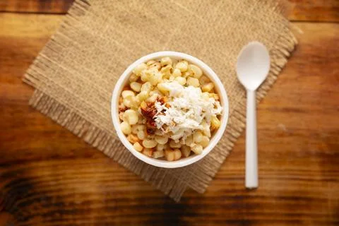 Esquites. Corn kernels cooked and served with mayo, sour cream, lemon and chi Stock Photos