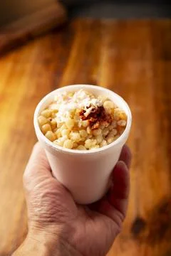Esquites. Corn kernels cooked and served with mayo, sour cream, lemon and chi Stock Photos