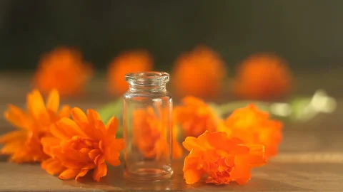 Essence of calendula flowers on table in beautiful glass bottle Stock Footage 112586702