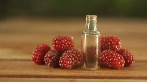 Essence of Wild raspberries  on table in beautiful glass Bottle Stock Footage 112583975