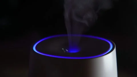 Essential oil diffuser releases smoke on a dark background. Selective focus Video stock 167818581