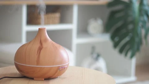 Essential oil diffuser releasing mist in a calm room with soft lighting. Stock Footage 333032617