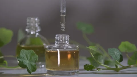 Essential Oil Product. Drops falling from cosmetic pipette to perfume bottle Stock Footage 144339810