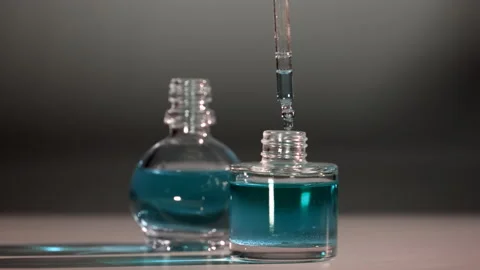 Essential Oil Product. Drops falling from cosmetic pipette to perfume bottle Stock Footage 144340374