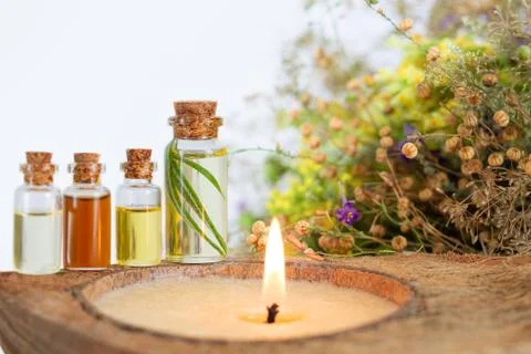 Essential oils spa set with burning candle, healthy herbs and flower Stock Photos