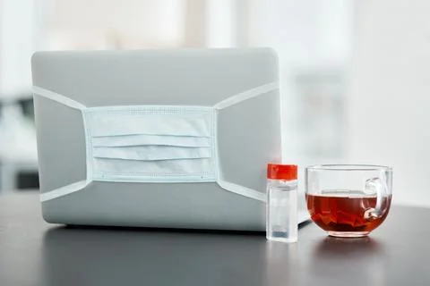 Essentials for a safe work station. a laptop, mask, hand sanitiser and herbal Stock Photos
