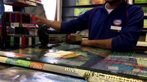 Esso clerk giving customer reciept for buying lottery ticket Stock Footage 65966441