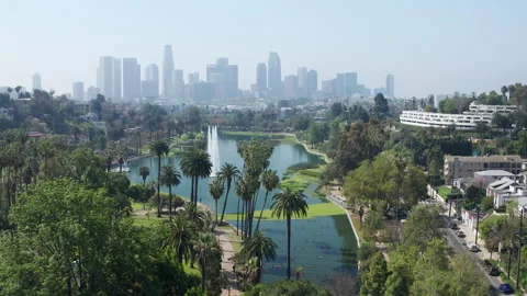 Establish shot of Echo Park Lake palm trees, fountain, LA skyline California Stock Footage 274024745