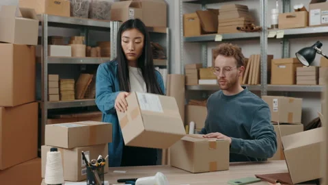 Established process. Two diverse male and female workers packing parcels while 스톡 동영상 169754064