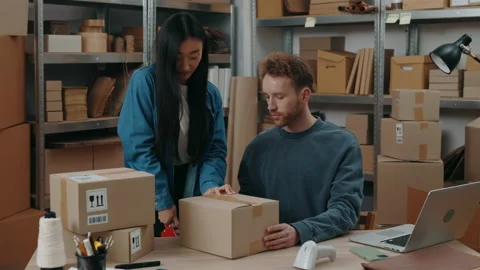 Established process. Two diverse people packing parcels while working together Video stock 169753900