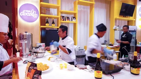 Established Shot of Open Kitchen for Cooking Demo at Busy Exhibition Booth Stock Footage 132019867