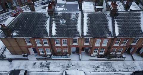 Establishing aerial pull back + climb from a snowy London, England house. Stock-Footage 86565481