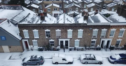 Establishing aerial pull back + climb from a snowy London, England house. Vídeos de archivo 86565823