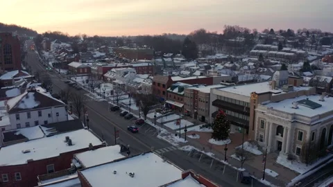 Establishing aerial of town in winter snow at sunrise, sunset. Christmas Stock Footage