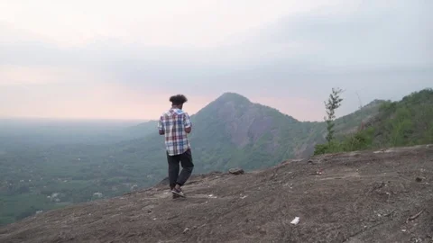 Establishing landscape of young man walking on mountain top nature travel Stock Footage 108894617
