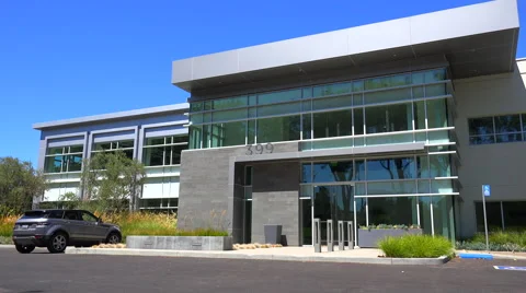 Establishing panning shot of the exterior of a generic modern office building. Stock Footage