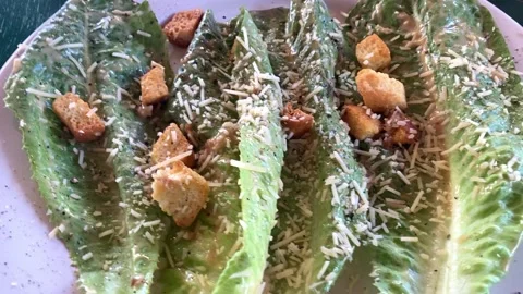 Establishing shot of a Caesar salad with lettuce leaves with croutons and Stock Footage 233665306