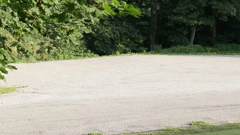 Establishing shot of empty parking lot near a local park Stock Footage