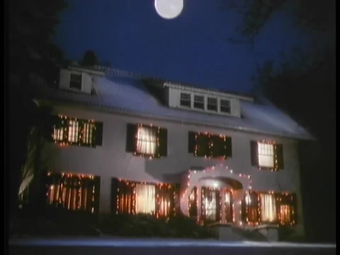 Establishing shot of full moon hovering over house decorated in Christmas l.. Stock Footage 260250923