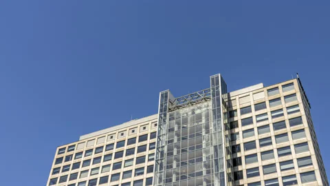 Establishing shot, generic office building against a blue sky timelapse Stock Footage 136531325