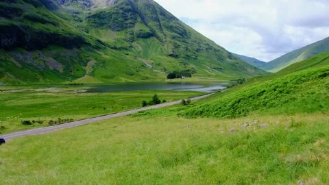 Establishing shot of Glen Coe with road in the Scottish Highlands Stock Footage 246747972
