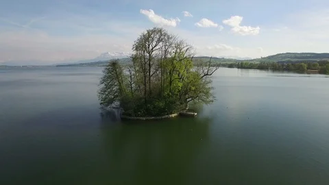 Establishing shot of lake landscape with tree island Vidéo 86853391