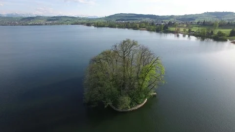 Establishing shot of lake landscape with tree island Stock Footage 86854625