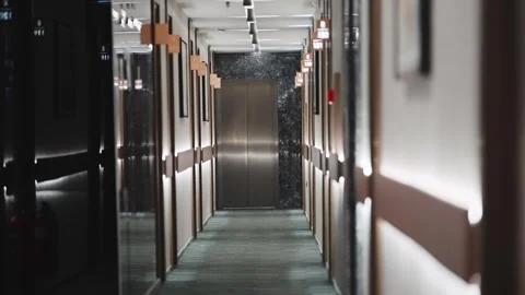 Establishing shot of long empty hallway corridor with a silver elevator in th Stock Footage 295298749