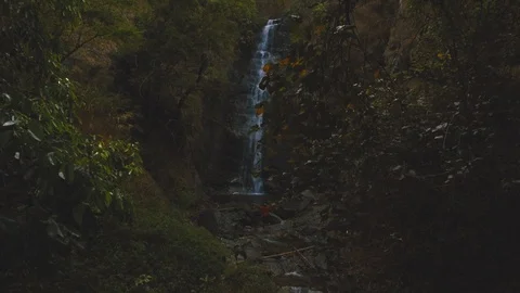 Establishing shot of man standing in front of beautiful waterfall Video stock 87297249