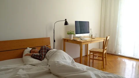 Establishing shot of man waking up late for working from home. Video stock 128769751