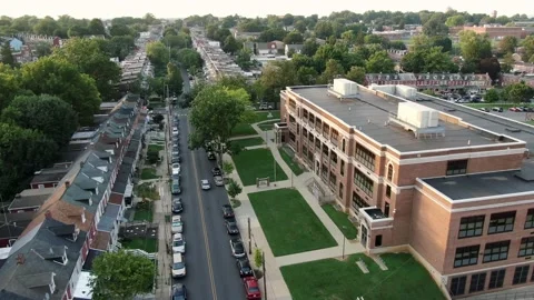 Establishing shot of public elementary school building exterior, aerial Stock Footage 136500591