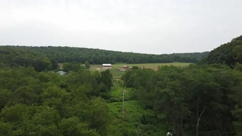 An Establishing Shot of a Red Barn While Flying Over Power Lines Stock Footage 158851959