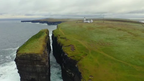 Establishing shot reveals layers of dramatic cliffs and sea stack at Loop Stock Footage 284742695