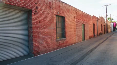 Establishing shot of rustic building and garage on an alley Stock Footage 65313925