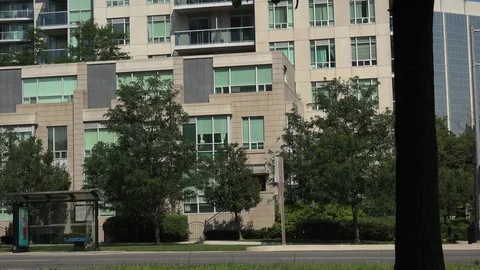 Establishing shot of traffic passing in front of townhouses. Stock Footage 78279931