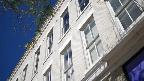 Establishing shot of a white bricked small town building during daytime Stock Footage 96467014