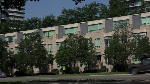 Establishing shot of white moving van passing in front of townhouses. Stock Footage 78279987