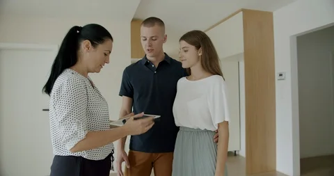 Estate agent doing house viewing with young couple and using digital tablet. Stock Footage 120511892