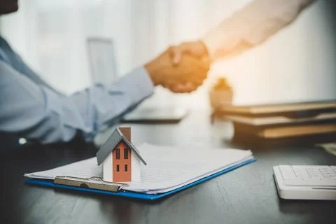 Estate agent shaking hands with client after contract signature and done busi Stock Photos