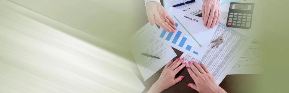 Estate agent showing the decrease of interest rates; panoramic b Stock Photos