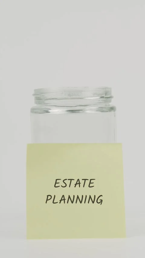 Estate planning text or word on yellow sticky note attached to glass jar Stock Footage 311727239