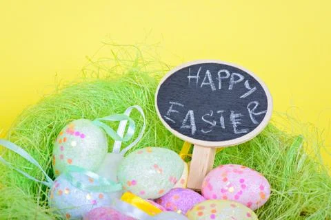 Ester eggs in nest with small blackboard Stockfoto's