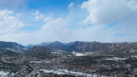 Estes Park mountain range with forested valley and snow patches 動画素材 334683996