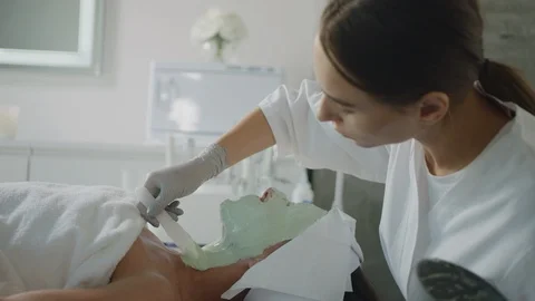 Esthetician does full face mask on client Видео 126339477
