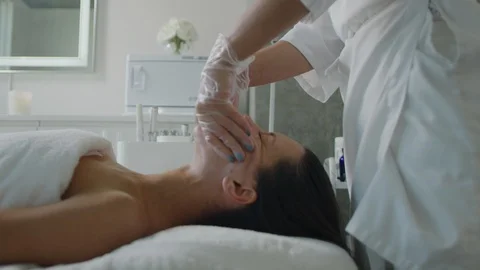 Esthetician massaging face, applying moisturizing cream Stock Footage 126339994