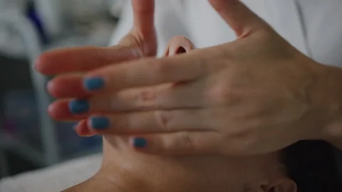 Esthetician massaging face, applying moisturizing cream 스톡 동영상 126341027